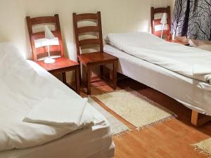 a room with two beds and two tables and chairs at Holiday home Hamnvik in Hamnvik