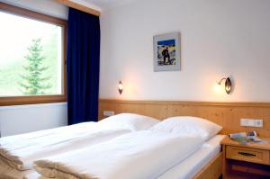 Schlafzimmer mit einem weißen Bett und einem Fenster in der Unterkunft Residence Zillertal in Gerlos