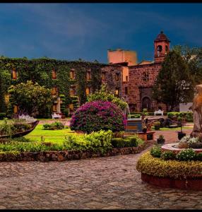 a large building with a garden in front of it at Posada de la Aldea in San Miguel de Allende