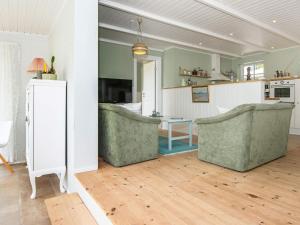 a living room with two chairs and a table at 8 person holiday home in Ebeltoft in Ebeltoft