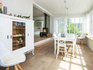 a kitchen with a table and a dining room at 8 person holiday home in Ebeltoft in Ebeltoft