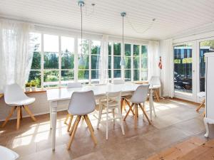 a dining room with a white table and chairs at 8 person holiday home in Ebeltoft in Ebeltoft