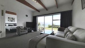 a living room with a couch and a bed and a window at 52sq Hawea Apartment, Lake and Mountain views!! in Wanaka