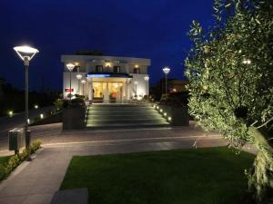 a building with stairs and lights at night at La Costiera Hotel in Marina di Varcaturo