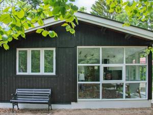 a bench sitting outside of a house with windows at 6 person holiday home in Str by in Strøby
