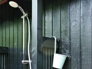 a shower with a bucket on the side of a building at 6 person holiday home in Str by in Strøby