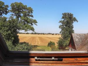 a window with a view of a field and a barn at 10 person holiday home in L DERUP in Löderup