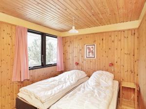 ブラーバンドにあるThree-Bedroom Holiday home in Blåvand 14の木製の壁のベッドルーム1室