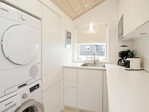 cocina blanca con fregadero y lavadora en 6 person holiday home in S by, en Saeby