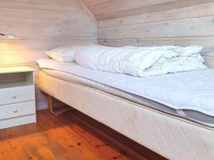 a bed in a room with a wooden wall at 9 person holiday home in Utsira-By Traum in Utsira +17 photos