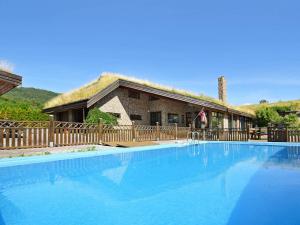 a large swimming pool in front of a house at 10 person holiday home in EIDSVÅG-By Traum in Rød