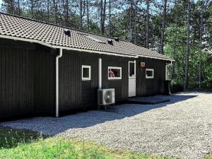 a black building with a tv sitting in front of it at 8 person holiday home in R dby in Rødby