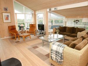 uma sala de estar com um sofá e uma mesa em 8 person holiday home in L kken em Lokken