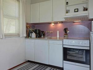 cocina con armarios blancos y fogones en Three-Bedroom Holiday home in Hasle 3, en Vang