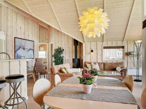 uma sala de estar com mesas e cadeiras e um lustre em Three-Bedroom Holiday home in Storvorde 6 em Egense