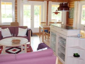 DannemareにあるTwo-Bedroom Holiday home in Dannemare 1の紫色のソファとテーブル付きのリビングルーム
