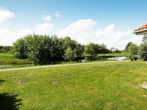 オッテルンドルフにある6 person holiday home in Otterndorfの池を背景にした草原