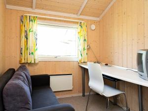 Asnæsにある7 person holiday home in Asn sのソファ、デスク、窓が備わる客室です。