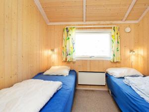 two beds in a small room with a window at 7 person holiday home in Asn s in Asnæs