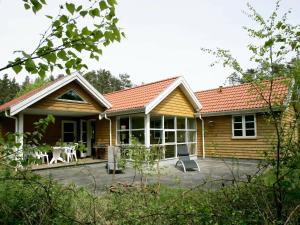 una casa in legno con un patio di fronte di 10 person holiday home in Aakirkeby a Vester Sømarken