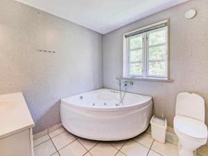 El baño incluye bañera blanca y aseo. en 10 person holiday home in Aakirkeby, en Vester Sømarken
