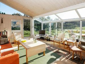 a living room with a lot of furniture and windows at 6 person holiday home in Løkken-By Traum in Løkken
