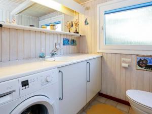 a bathroom with a washing machine and a sink at 6 person holiday home in Løkken-By Traum in Løkken