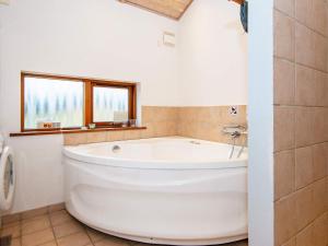 a large white tub in a bathroom with a window at 7 person holiday home in Ulfborg in Thorsminde