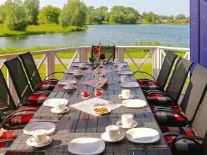 a long table with chairs and plates and wine glasses at 12 person holiday home in Otterndorf in Otterndorf