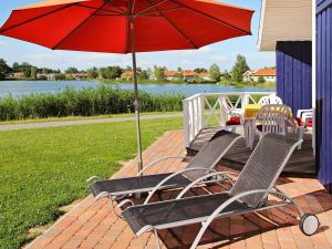 a pair of chairs and an umbrella on a patio at 12 person holiday home in Otterndorf in Otterndorf