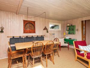 jadalnia z drewnianym stołem i krzesłami w obiekcie Two-Bedroom Holiday home in Ringkøbing 9 w mieście Søndervig