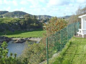 a fence next to a river next to a field at 4 person holiday home in EGERSUND in Egersund