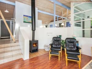 a living room with two chairs and a fireplace at 12 person holiday home in Glesborg in Fjellerup Strand