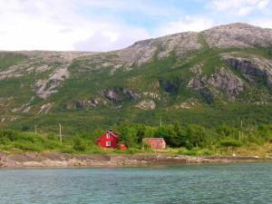 ein rotes Haus am Ufer eines Berges in der Unterkunft 6 person holiday home in Vevelstad in Vevelstad