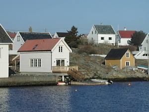 a group of houses next to a body of water at 7 person holiday home in Utsira-By Traum in Utsira