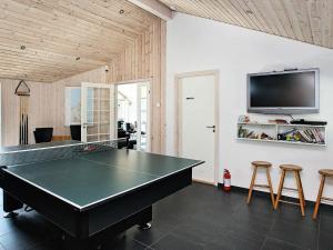eine Tischtennisplatte in einem Zimmer mit einem TV in der Unterkunft 8 person holiday home in lb k in Ålbæk