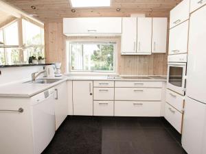 eine weiße Küche mit weißen Schränken und einem Fenster in der Unterkunft 8 person holiday home in lb k in Ålbæk