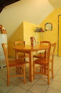 een houten eettafel en stoelen in een kamer bij Gîtes de Loire in Mosnes