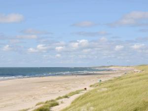 a beach with people on the sand and the ocean at 6 person holiday home in Hvide Sande in Hvide Sande