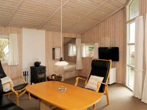 Sønder BjertにあるTwo-Bedroom Holiday home in Bjert 1のリビングルーム(テーブル、椅子付)