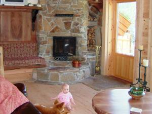Ualandにある10 person holiday home in Ualandの石造りの暖炉のあるリビングルームに赤ちゃん