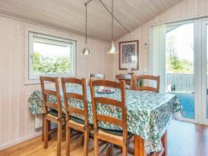 a dining room with a table and chairs and a window at 6 person holiday home in Hemmet in Falen