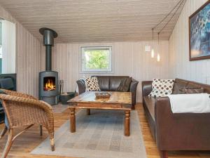a living room with a couch and a fireplace at 6 person holiday home in Hemmet in Falen