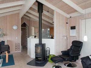 a living room with a stove and two chairs at 8 person holiday home in Ebeltoft-By Traum in Ebeltoft