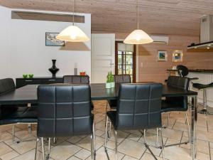 comedor con mesa y sillas negras en 6 person holiday home in Bl vand, en Blåvand