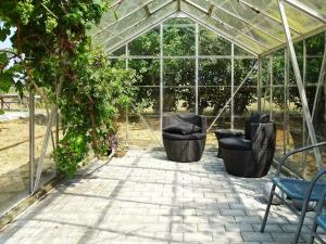 エーロスケービンにある14 person holiday home in r sk bingの籐の椅子と椅子が置かれた温室です。