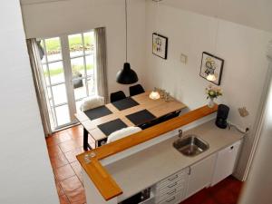 uma cozinha e sala de jantar com uma mesa e um lavatório em Holiday Home Horns Bjerge IV em Blåvand