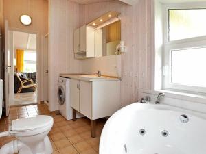 a bathroom with a tub and a toilet and a sink at 6 person holiday home in GROEMITZ in Grömitz