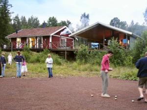 un grupo de personas jugando dominó frente a una casa en 8 person holiday home in GR NNA, en Målskog