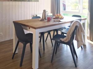a wooden table with chairs and a bowl of fruit at 6 person holiday home in Otterndorf in Otterndorf